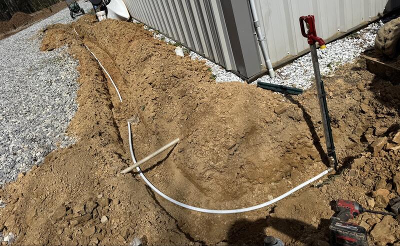 Water service line trenched to a metal building with a new yard hydrant set in place